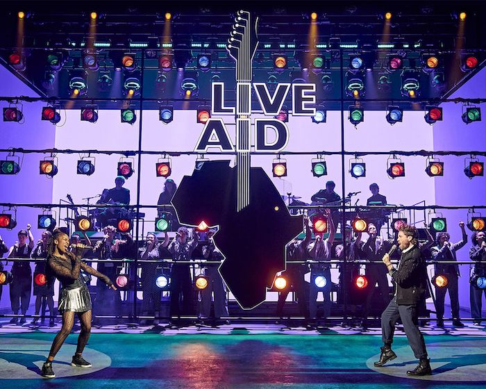 2 singers with band and Live Aid logo