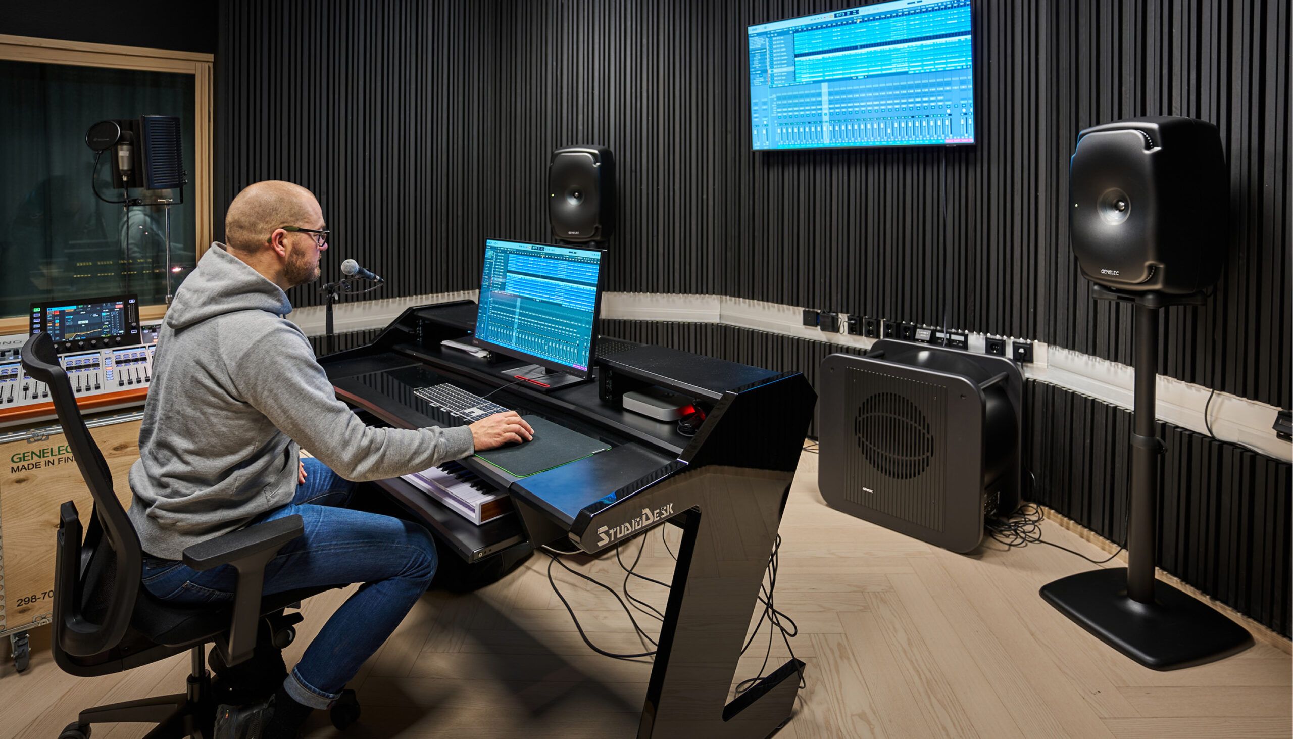 performing arts school music studio space with player at keyboard facing monitors, audio equipment