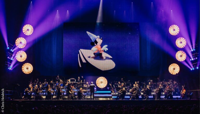 View to stage with orchestra in front of a screen showing Mickey Mouse