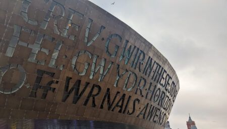 Close-up view of Wales Millennium Centre's distinctive bronze dome with carved Welsh and English text