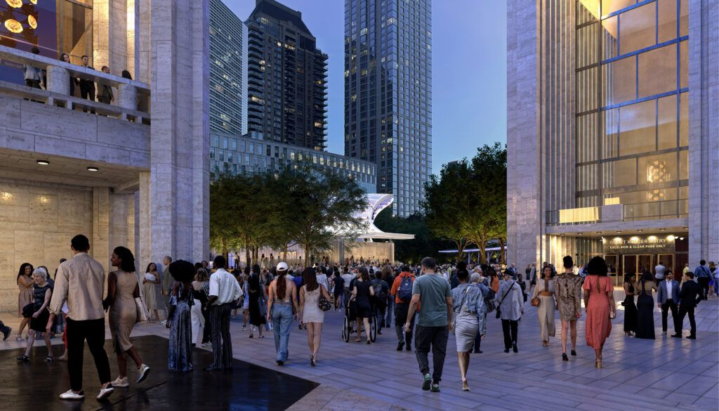 Evening scene at cultural complex with crowds walking through illuminated plaza. Modern glass and stone buildings frame an open gathering space with trees integrated throughout.