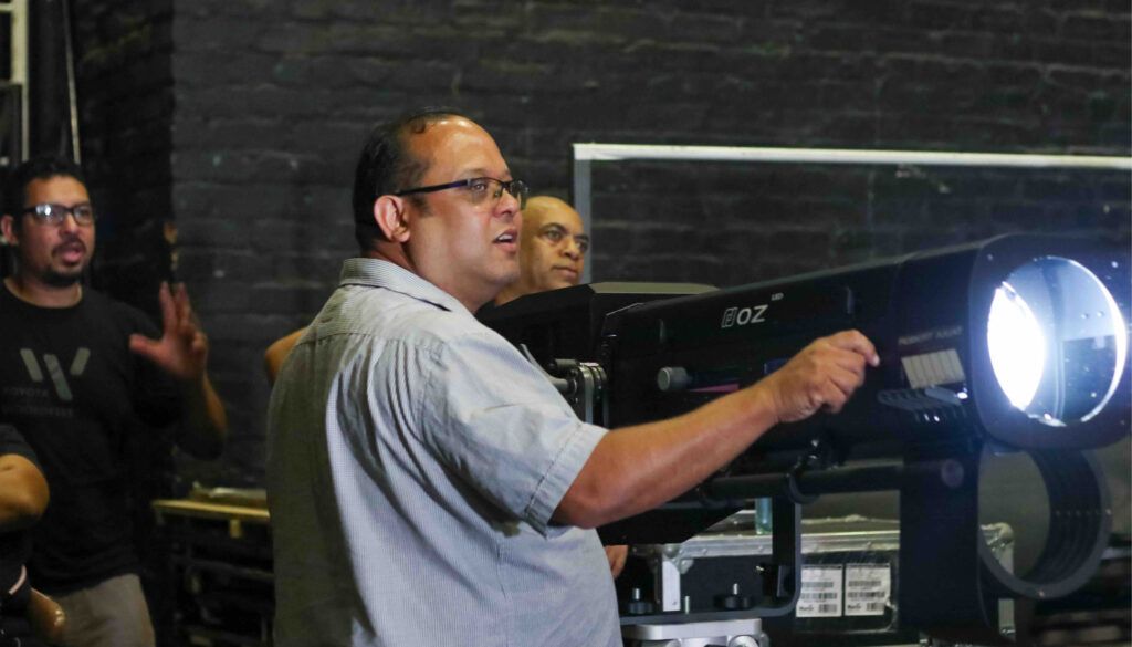 Man operating professional lighting equipment with bright beam