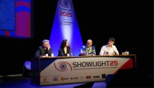 Four panellists seated at Showlight 2025 conference table discussing topics on stage with branded backdrop