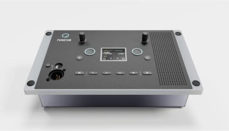 Professional audio intercom control panel with two knobs, buttons, display screen, speaker grille, and connector on silver chassis
