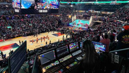Basketball arena with broadcast control equipment overlooking sold-out crowd