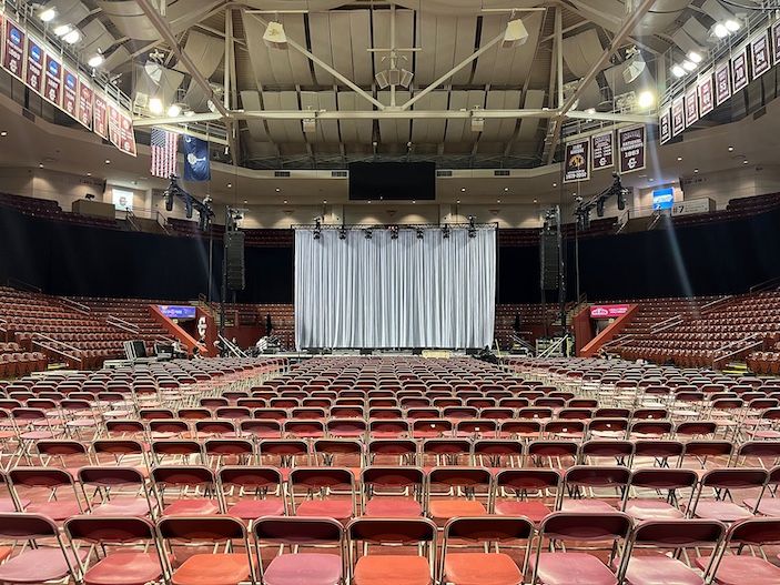 Arena interior with red chairs and stage backdrop curtain