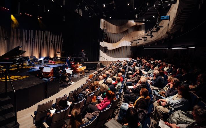 Concert hall with instrumentalists on stage in front of seated audience