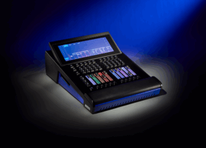 The ETC Hog Tour Wing lighting playback controller shown in three-quarter view against a dark blue background, with RGB-backlit faders and a dashboard touchscreen display visible.