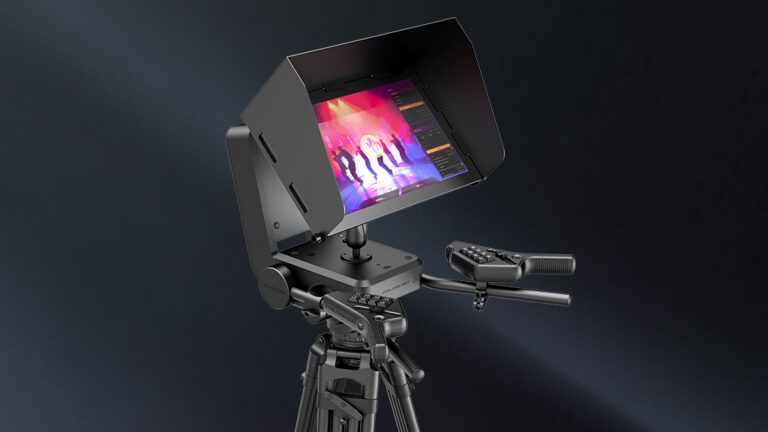 The Falconer base station, a hooded touchscreen showing a live stage view, mounted on a tripod construction with two control handles with buttons.