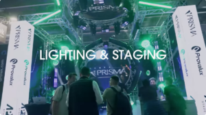 Visitors at a green-lit trade show stand with lighting rigs
